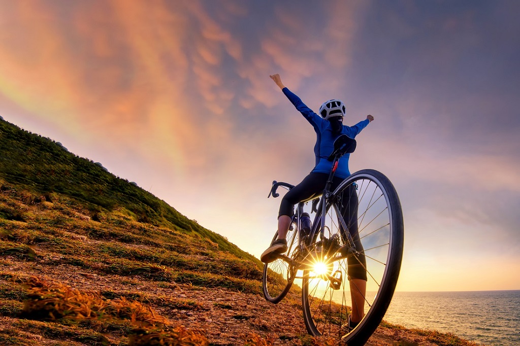 Bike cyclist standing on top of a mountain with bicyc